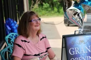 Woman wearing glasses smiling while seated during a Legacy Vans moment