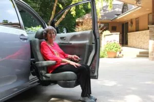 Woman using a powered transfer seat in a wheelchair-accessible van