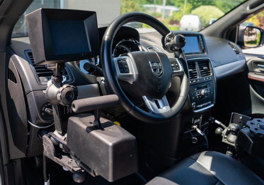 Adaptive hand controls installed on the steering wheel of a wheelchair accessible van